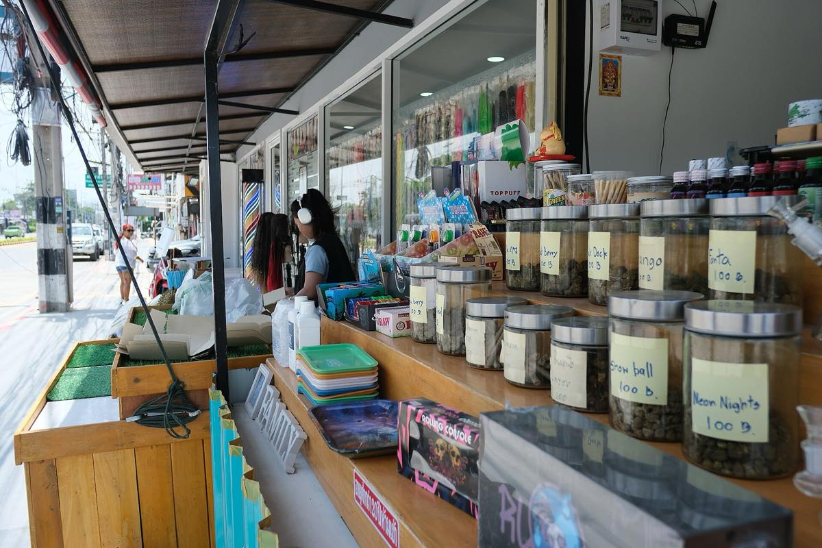 แผงขายของหน้าร้านริมถนน มีขนมและของใช้เรียงเป็นแถว