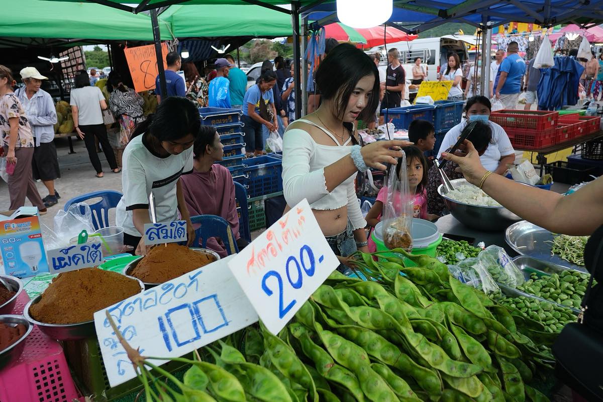 คนขายกำลังจัดของใส่ถุงให้ลูกค้า